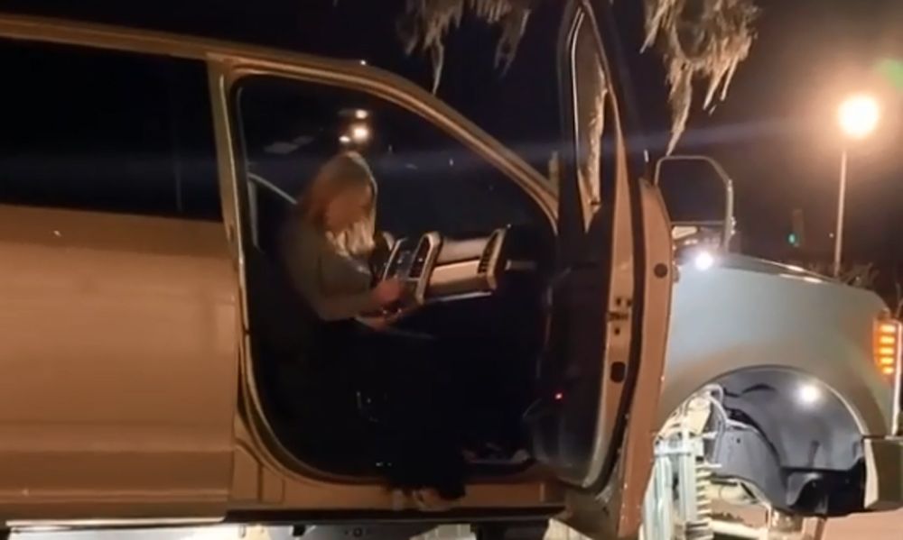 Woman sitting in cab of lifted pickup truck