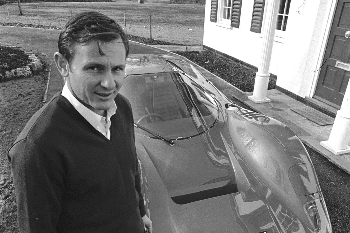 Bruce McLaren Standing Next To A Race Car