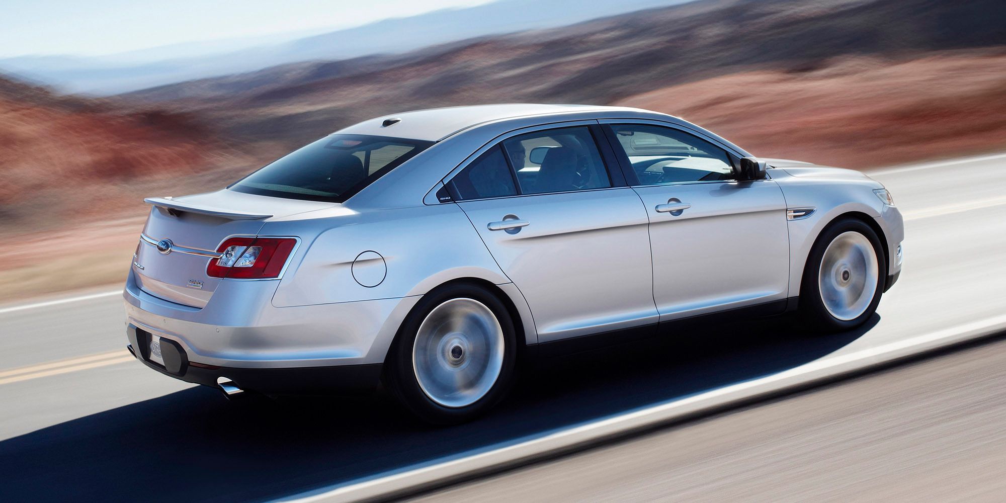 Side view of a silver Taurus SHO on the move
