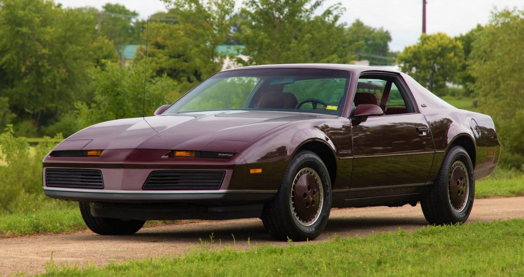 Burgundy Pontiac Firebird Trans Am parked outside