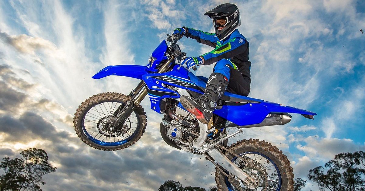 Man in blue riding 2021 Yamaha WR450F at sunset