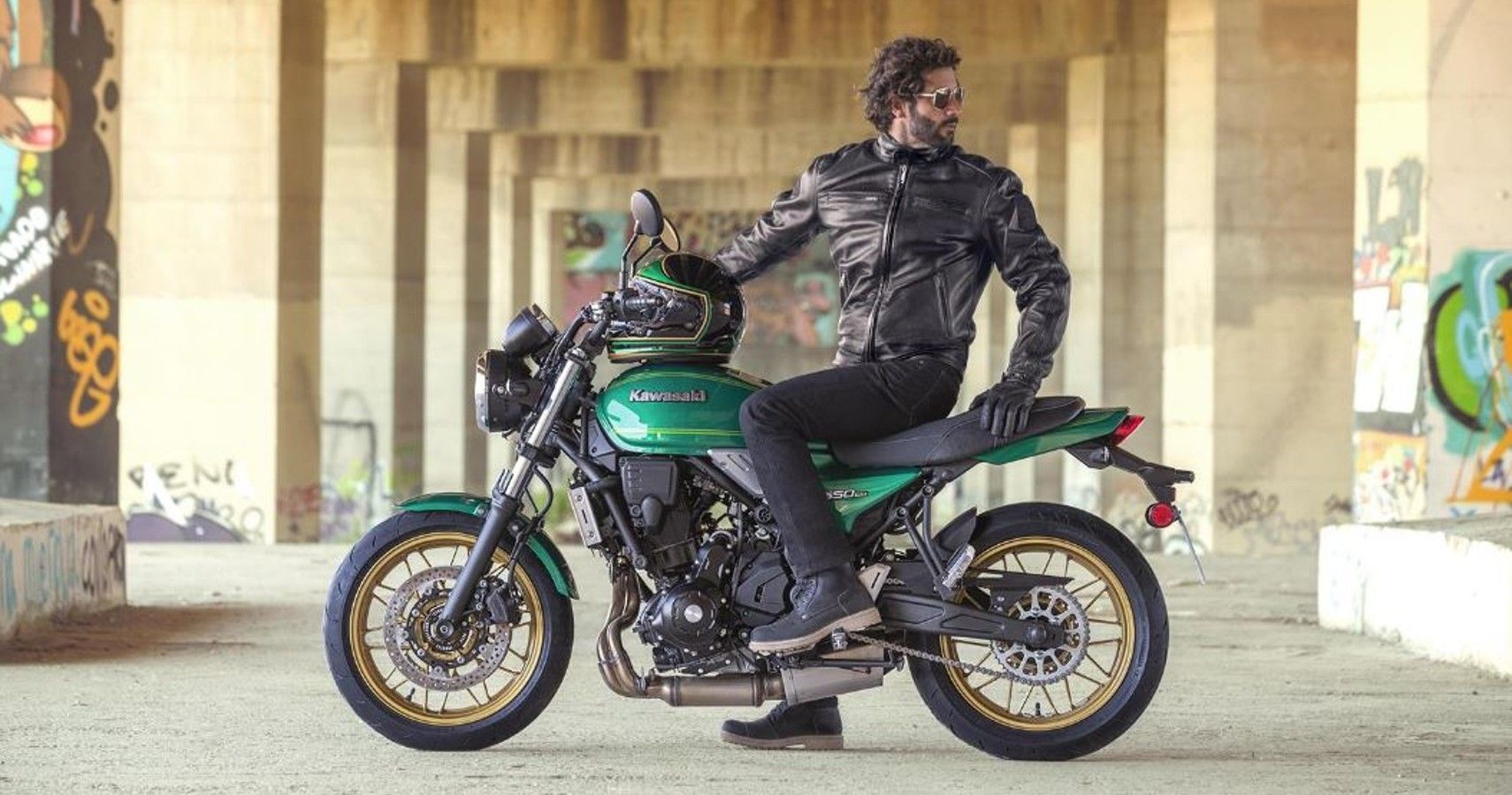 A rider on a parked green 2022 Kawasaki Z650RS.