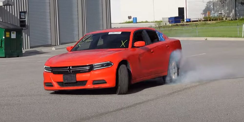 Red 2017 Dodge Charger performs a burnout in parking lot