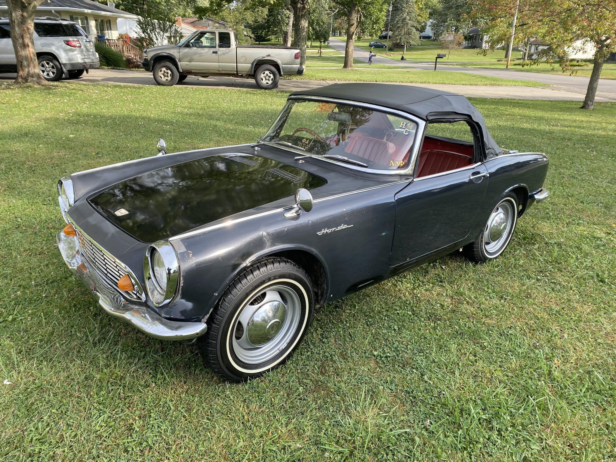 A black Honda S600 with roof up