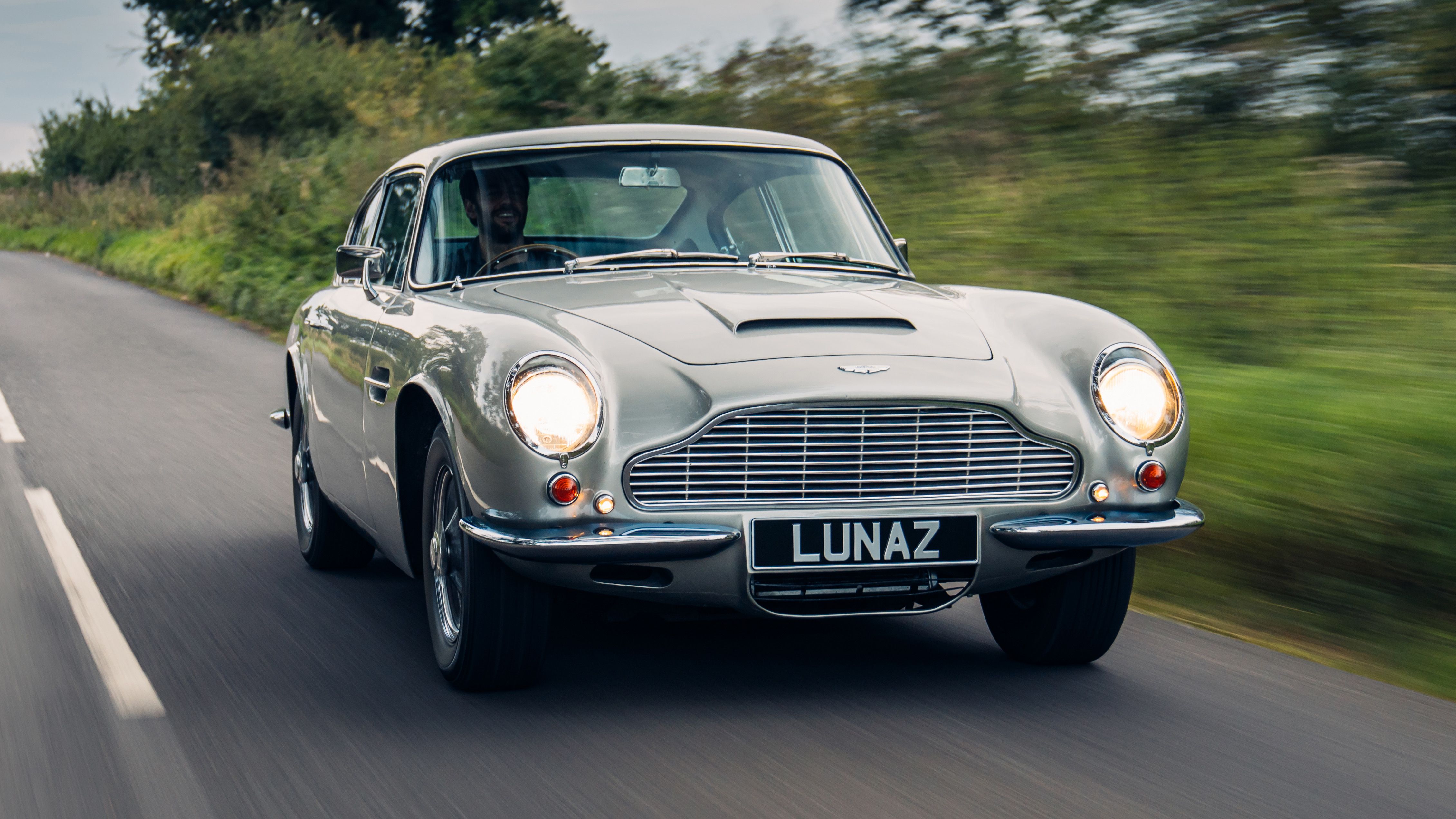 An Image Of A Aston Martin DB6 In Motion