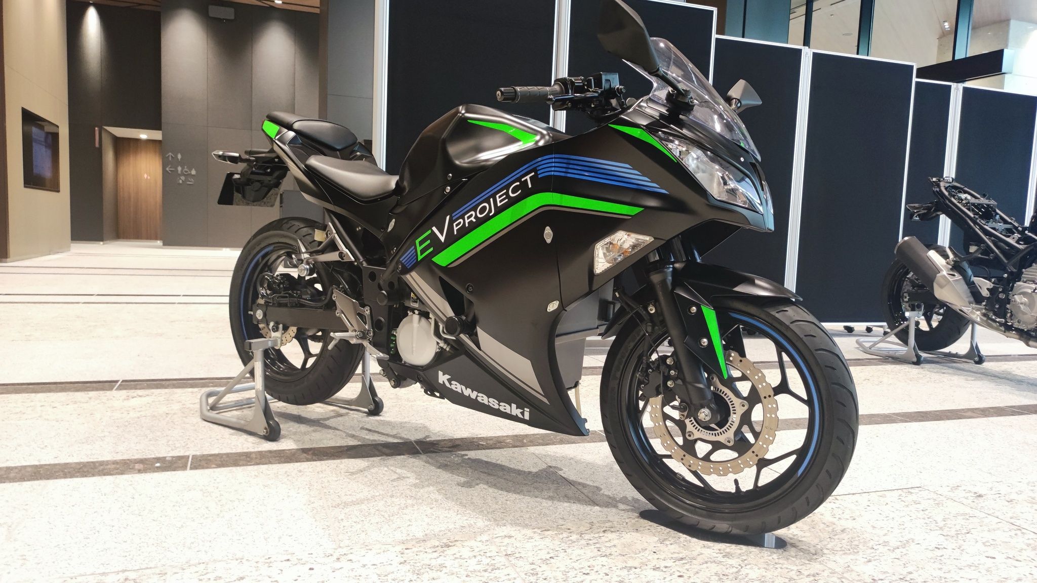 Several Kawasaki Hybrid Motorcycles parked indoors