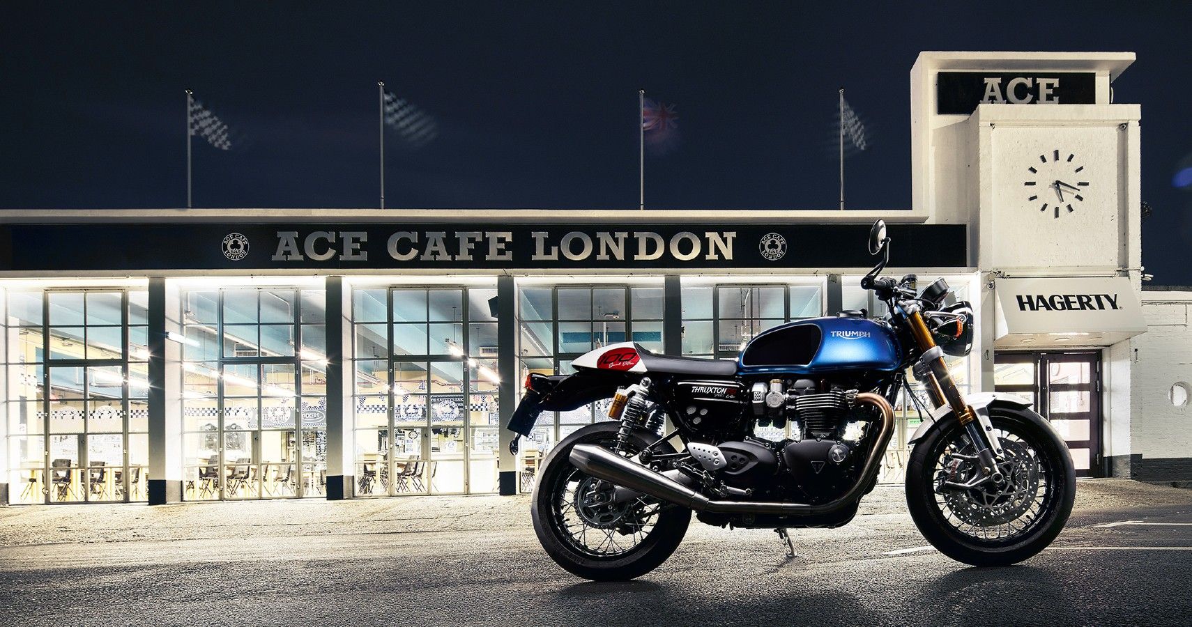 A 2022 Triumph Thruxton Ton Up special edition parked outside the Ace Cafe at night.