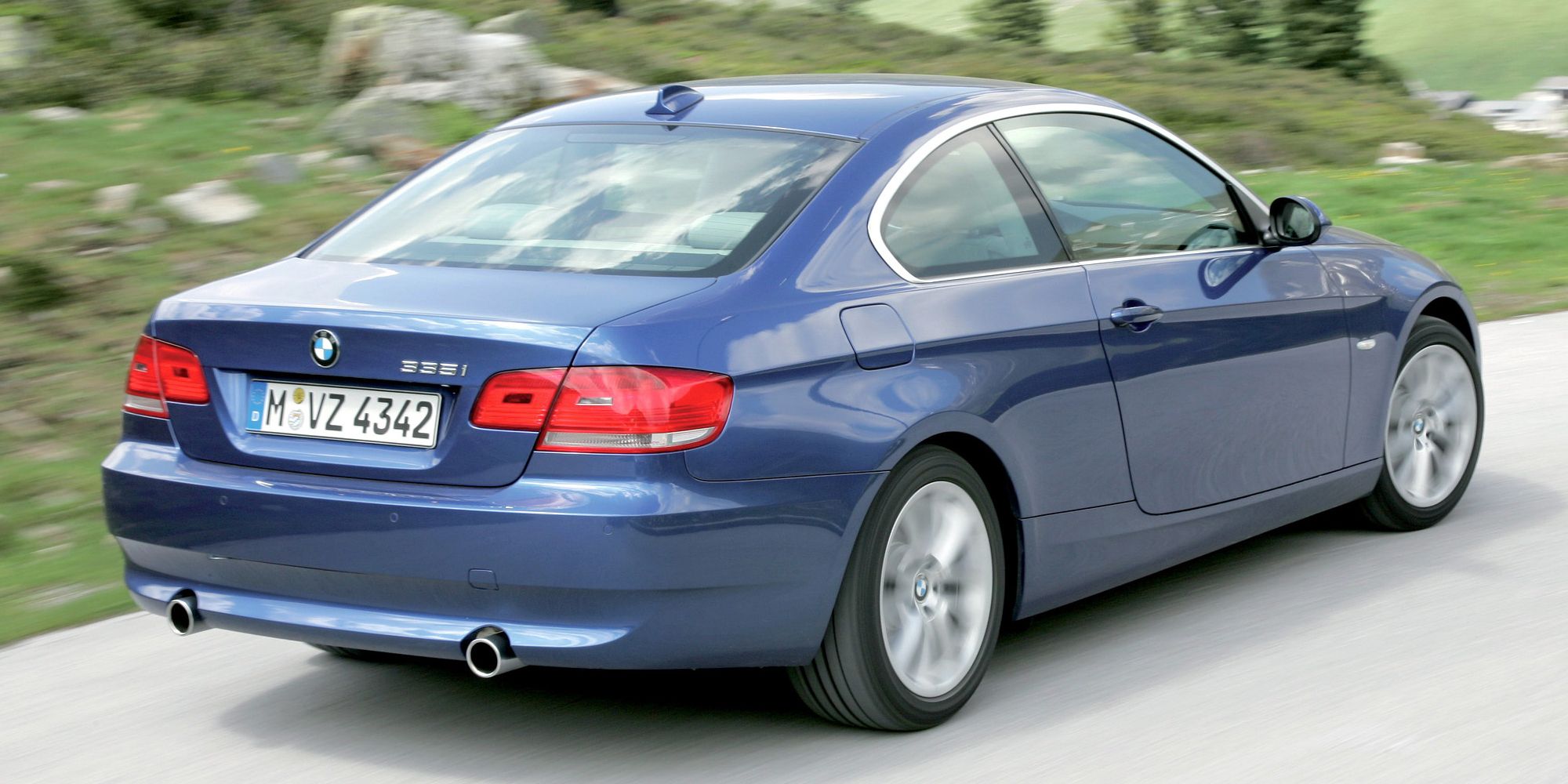 Rear 3/4 view of a blue 335i on the move