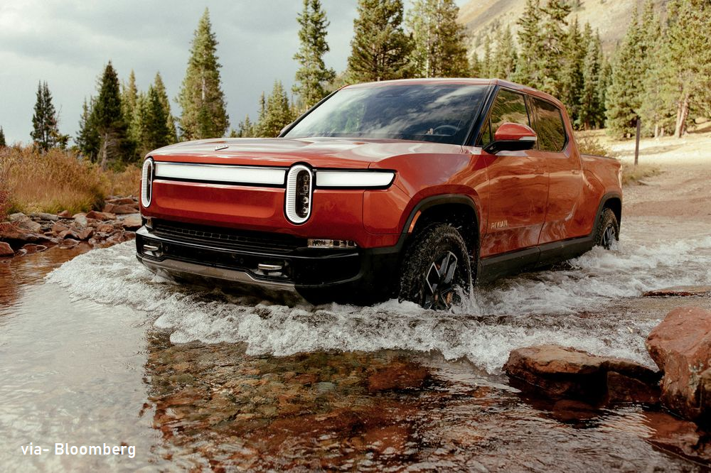 Rivian R1T truck, red, wading through water