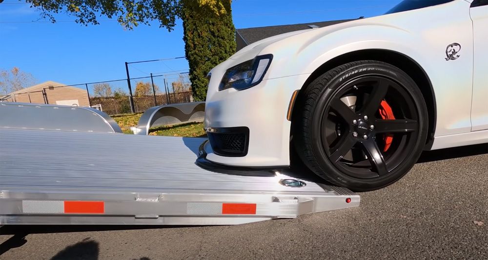 White Chrysler 300 Hellephant slowly crawling up trailer