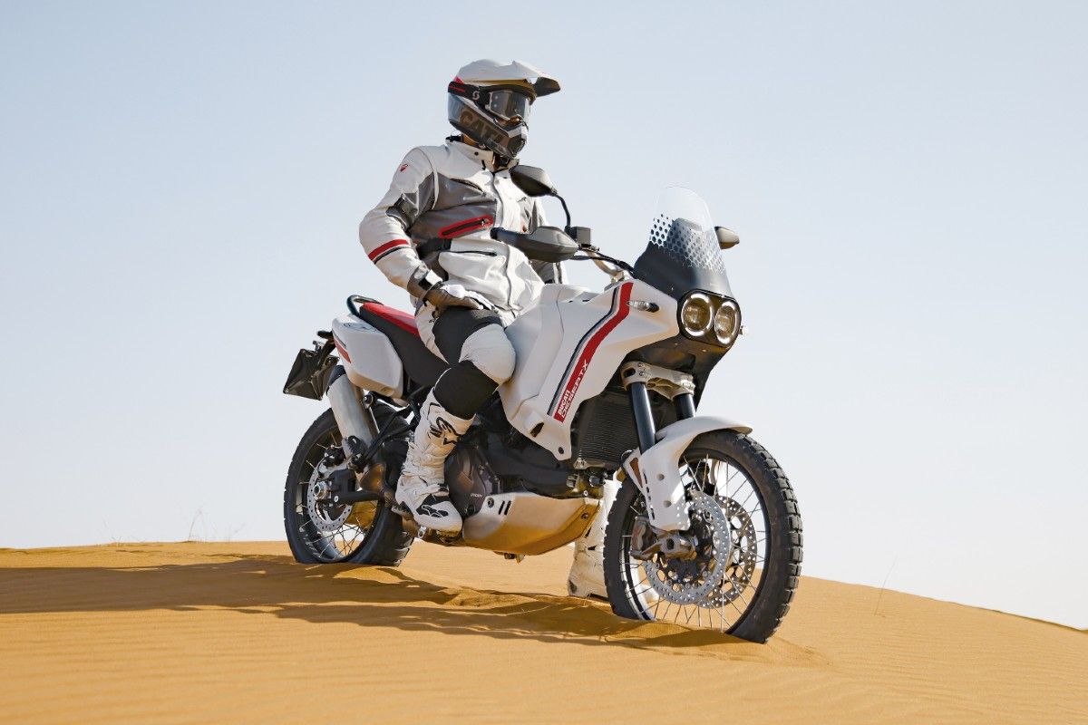 A rider stopped on a dune on a 2022 Ducati DesertX.