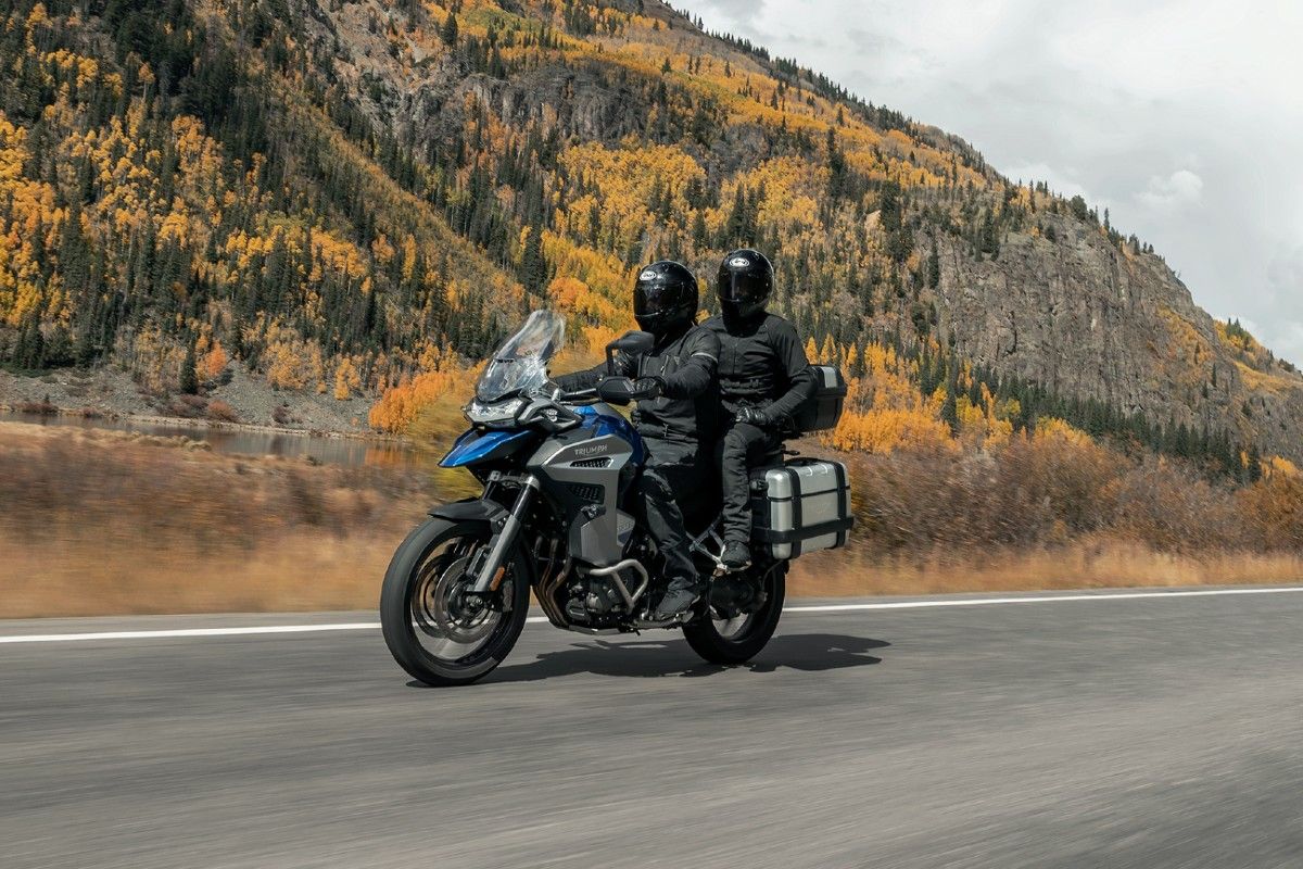 A rider and passenger cruising down the highway on a 2022 Triumph Tiger 1200 GT Explorer.