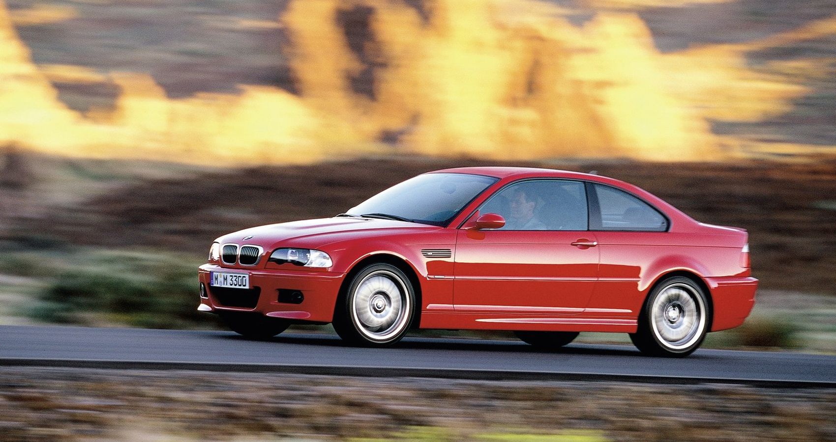 Front 3/4 view of a red E46 M3 on the move