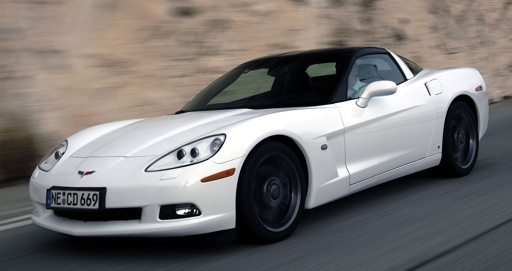 Front 3/4 view of a white C6 Corvette on the move