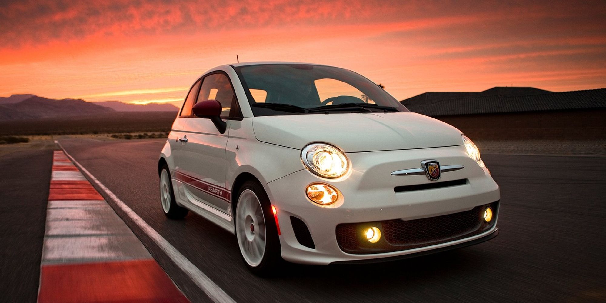 The front of a white 500 Abarth on track