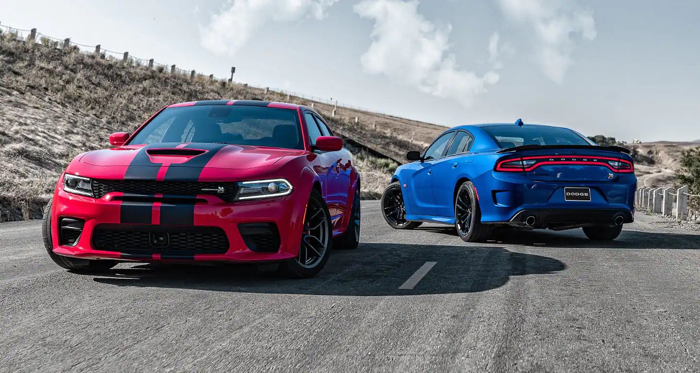 Two Dodge Charger SRT Hellcats, one blue and one Red on the road