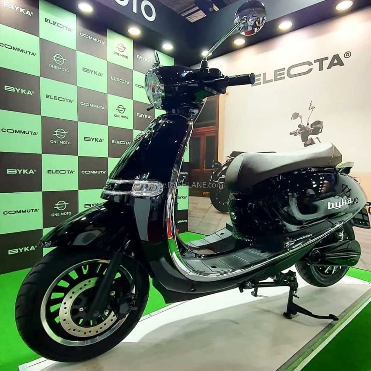 One Moto Electa displayed in front of green wall