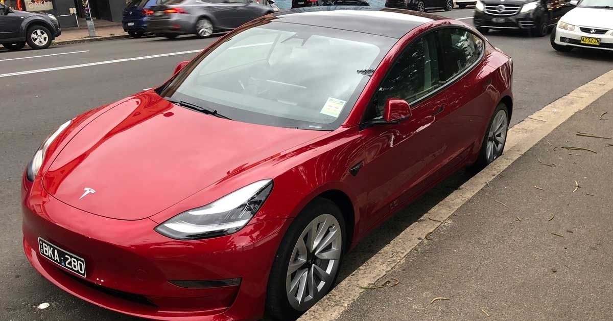Red Tesla Model 3 parked outside, top view