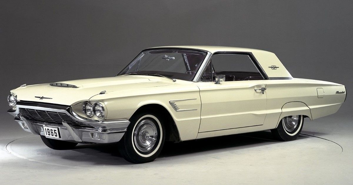 1965 Ford Thunderbird, cream, front quarter view, grey backdrop