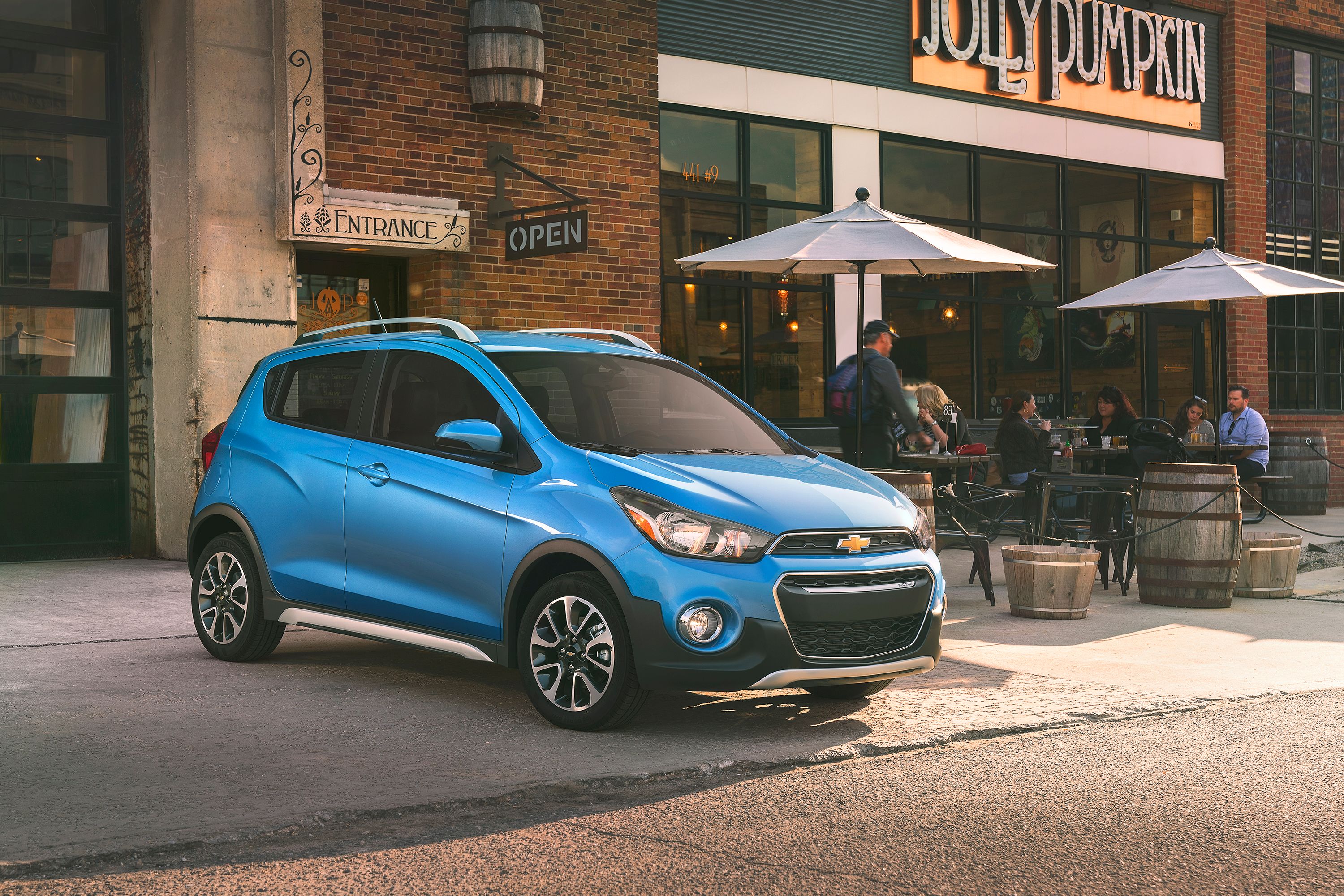 Blue Chevy Spark parked in front of building