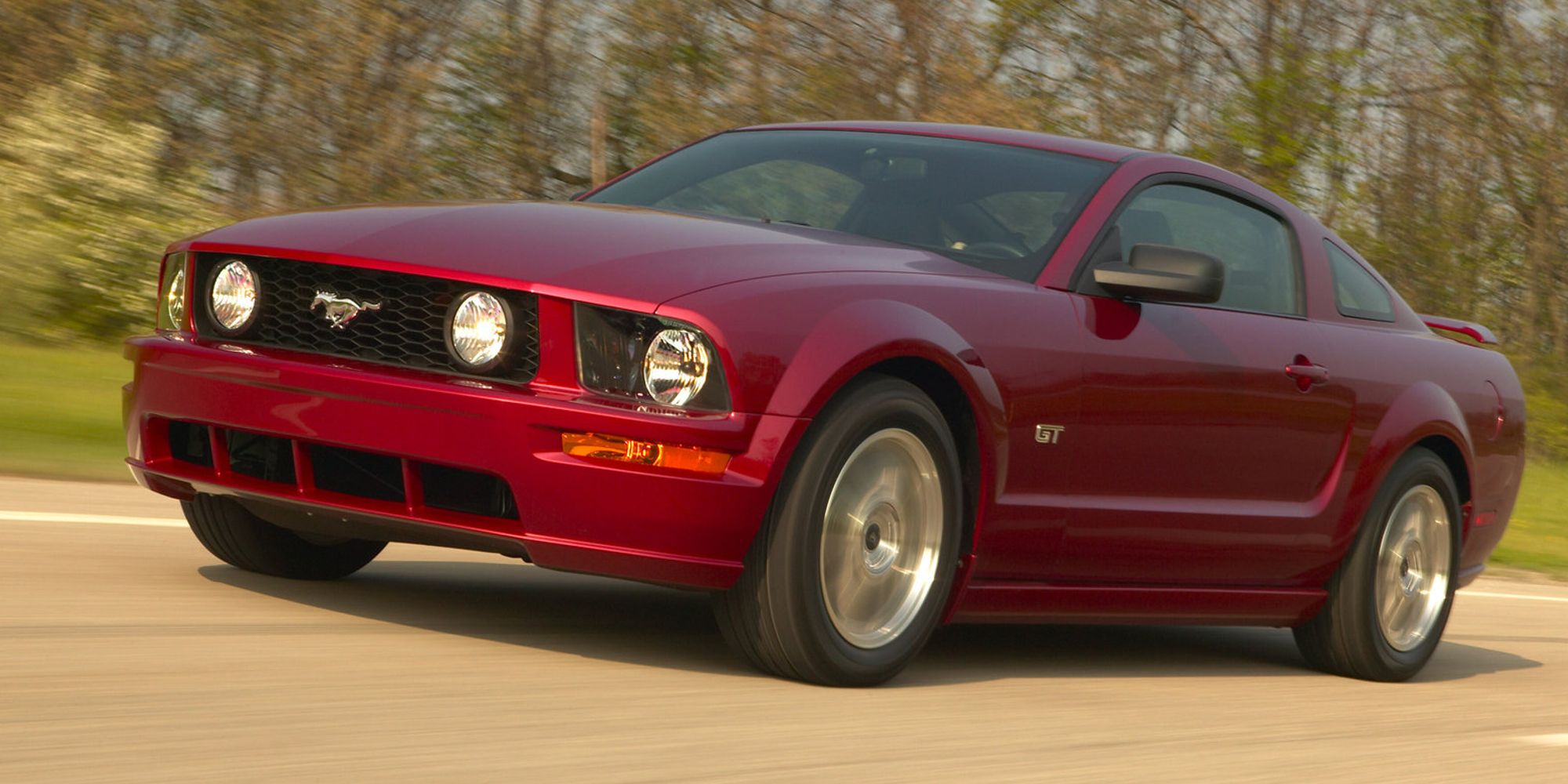 Front 3/4 view of a red S197 Mustang on the move