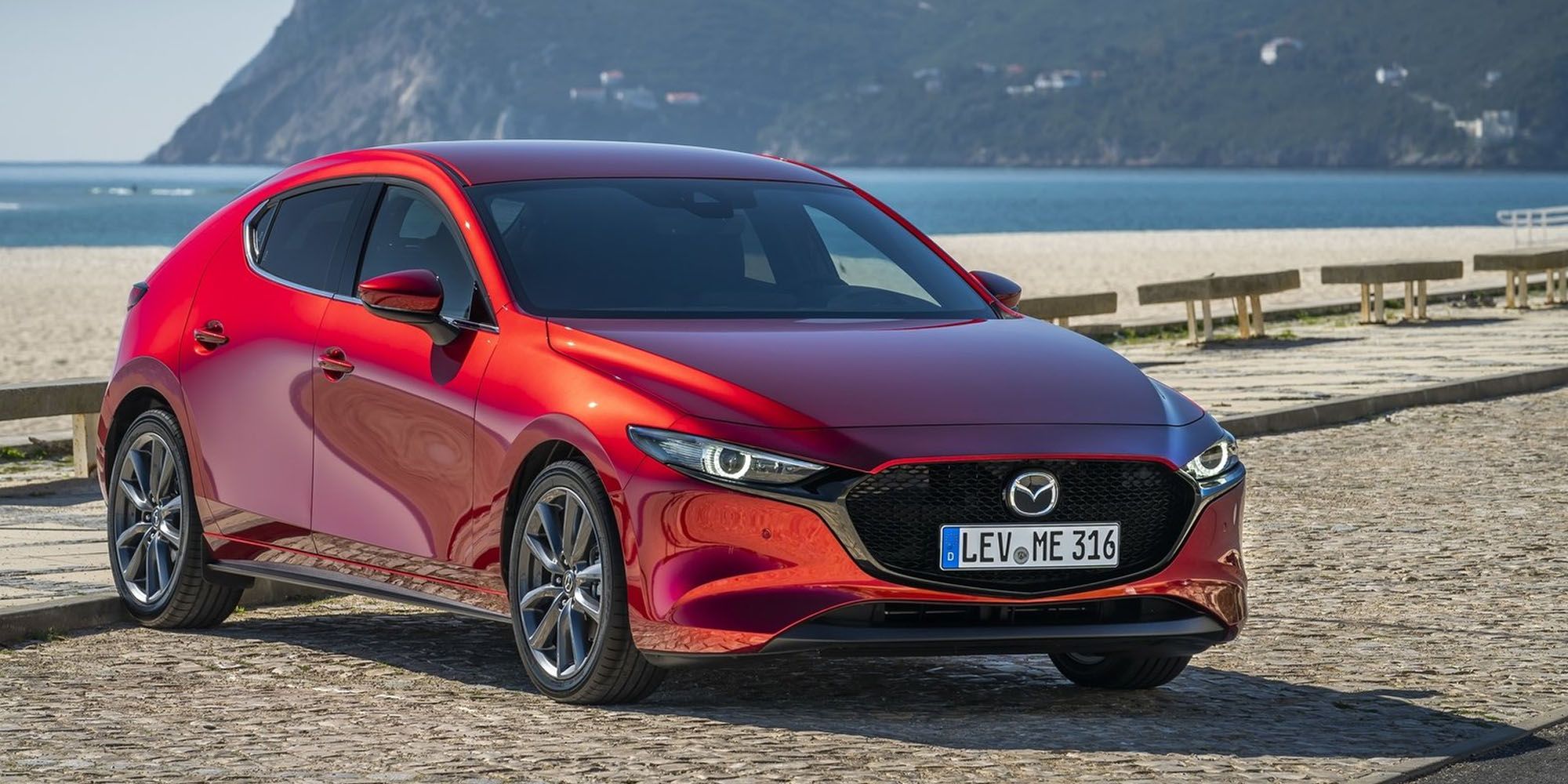 The front of a red Mazda 3