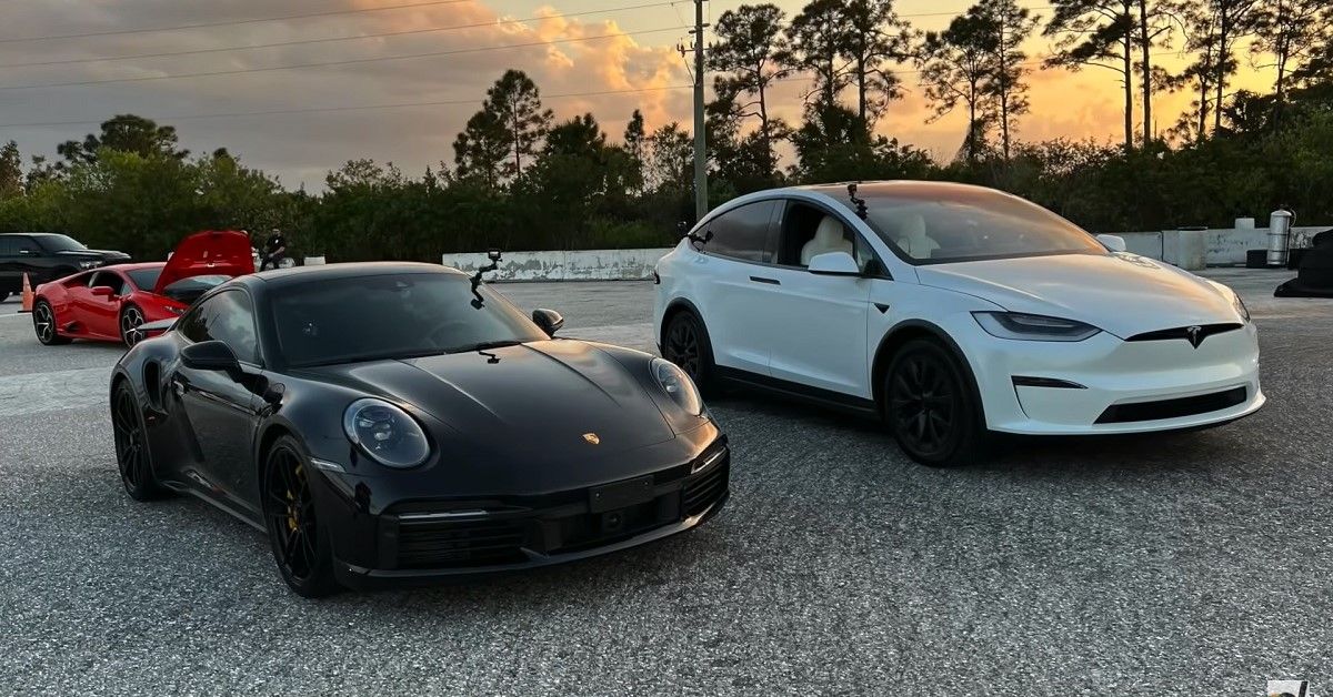 Porsche 911 Turbo S 992 and Tesla Model X Plaid, parked side by side in parking lot