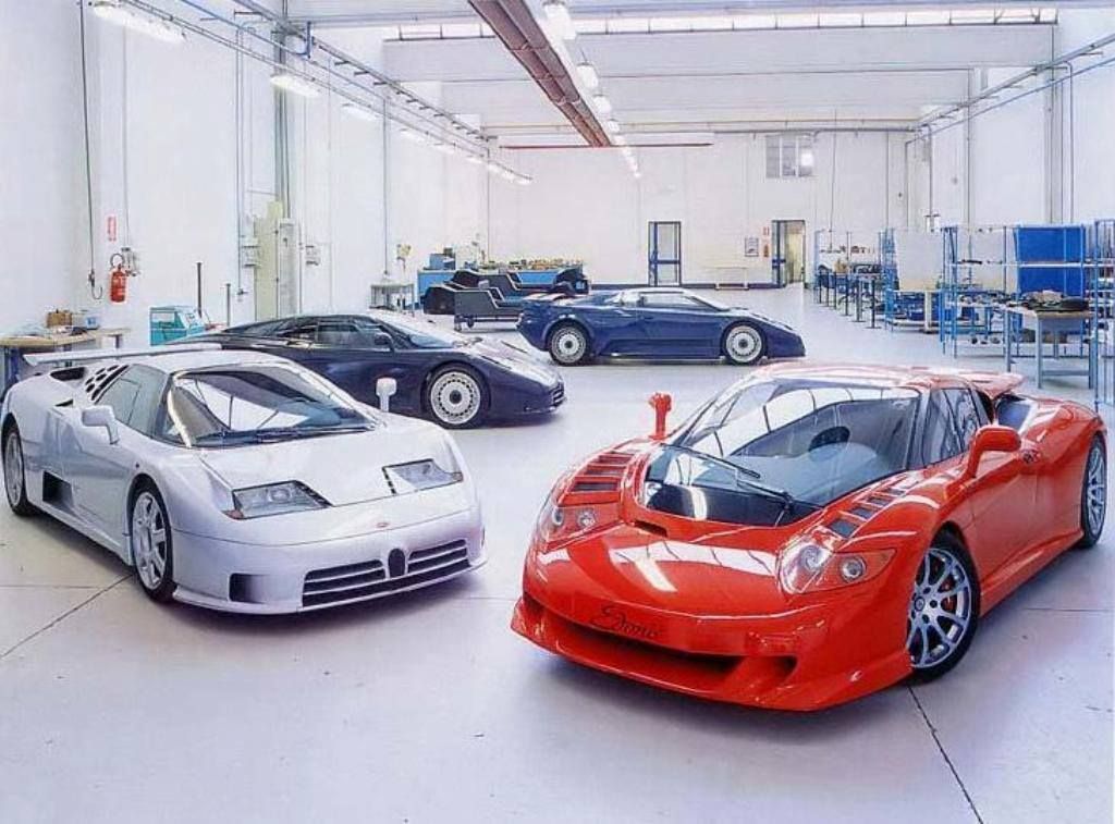 A group of Bugattis in a workshop