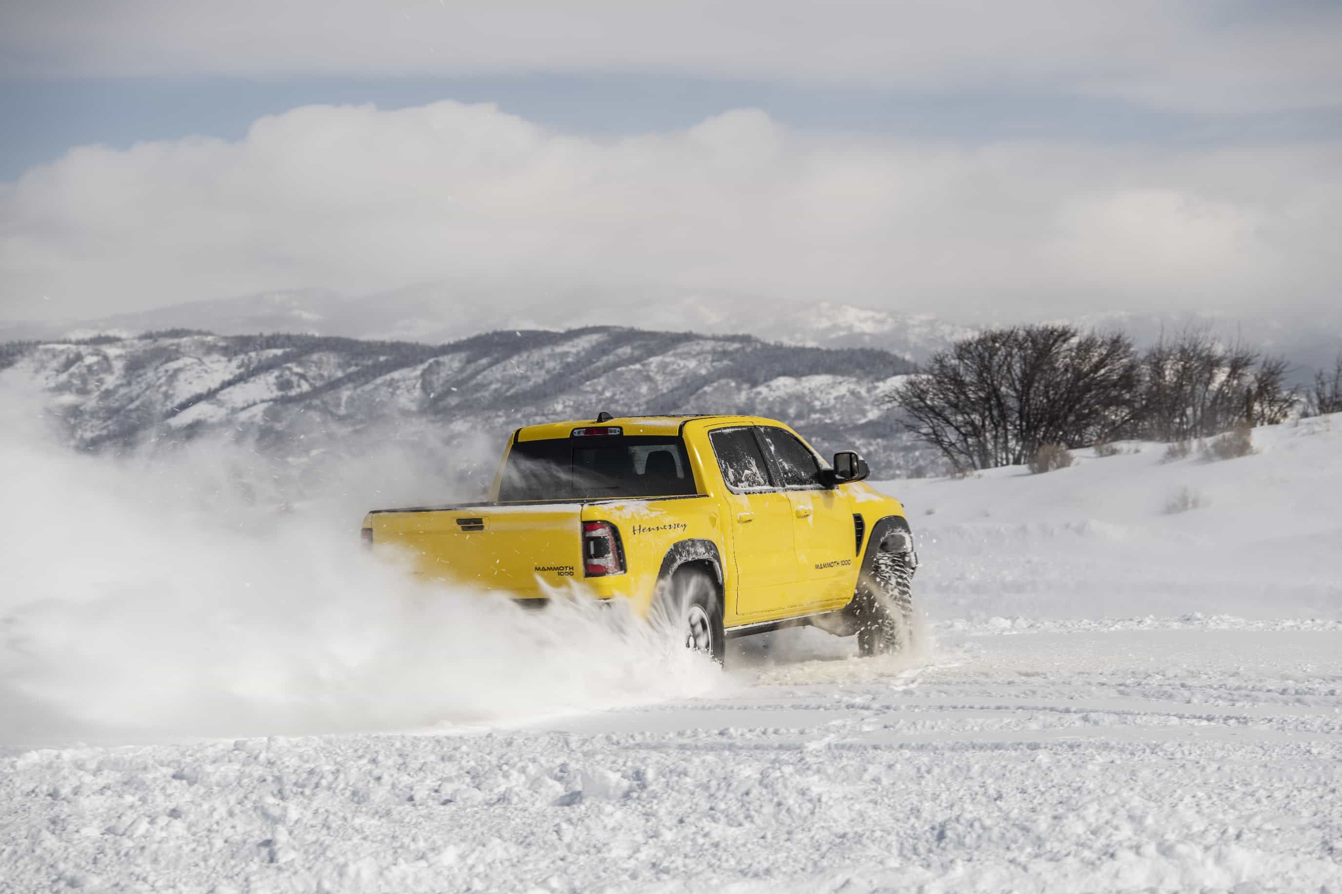 Hennessey Ram 1500 TRX Mammoth, yellow, rear quarter view, speeding in snow