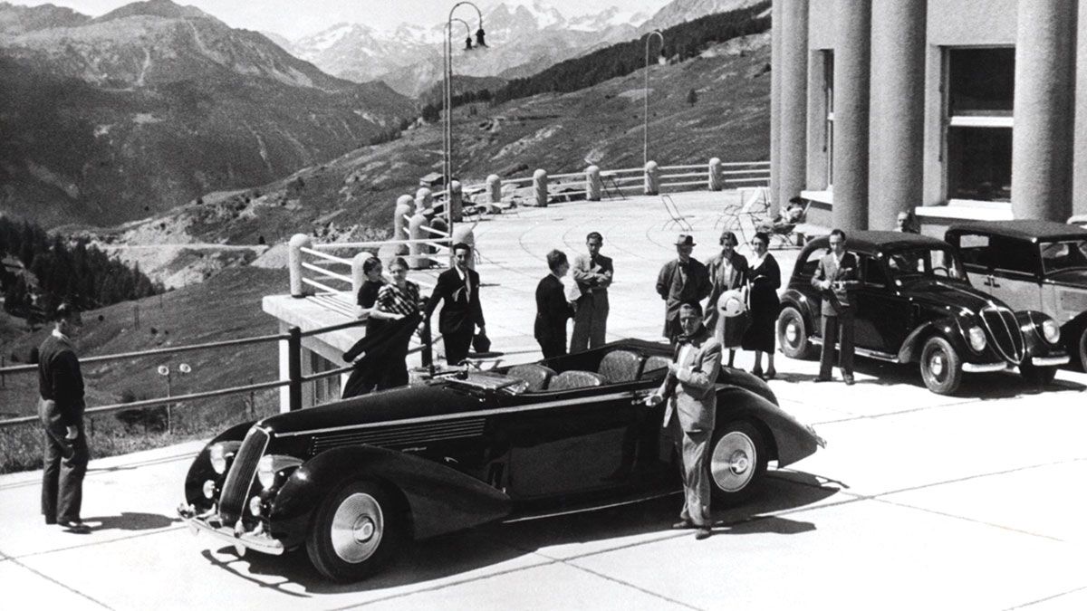 The 1936 Lancia Astura Cabriolet surrounded by people.