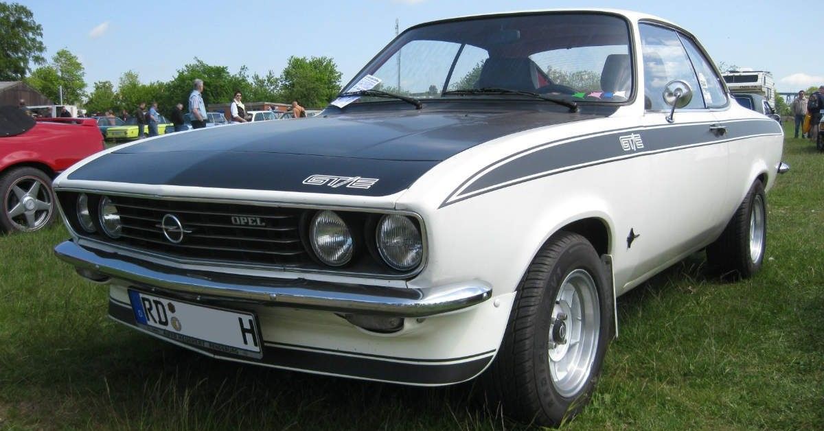 Manta A GTE, white/black, front-quarter, parked on grass at show