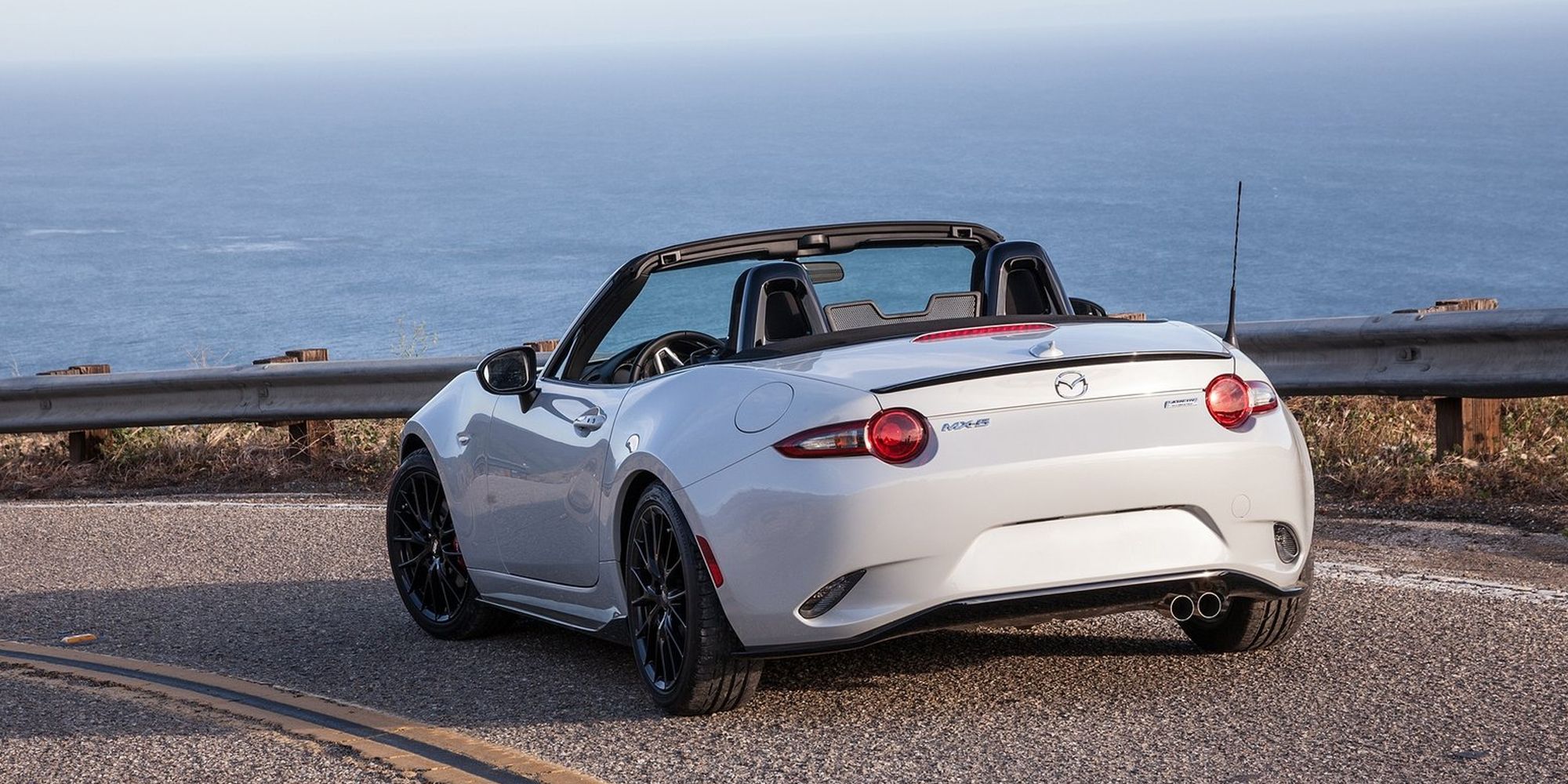 The rear of the MX-5 Club in white on a coastal road