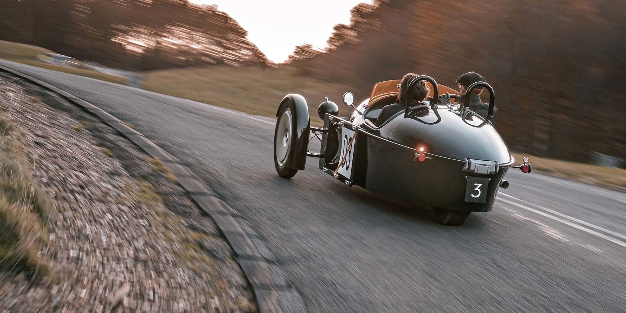 The rear of a green Super 3 taking a corner