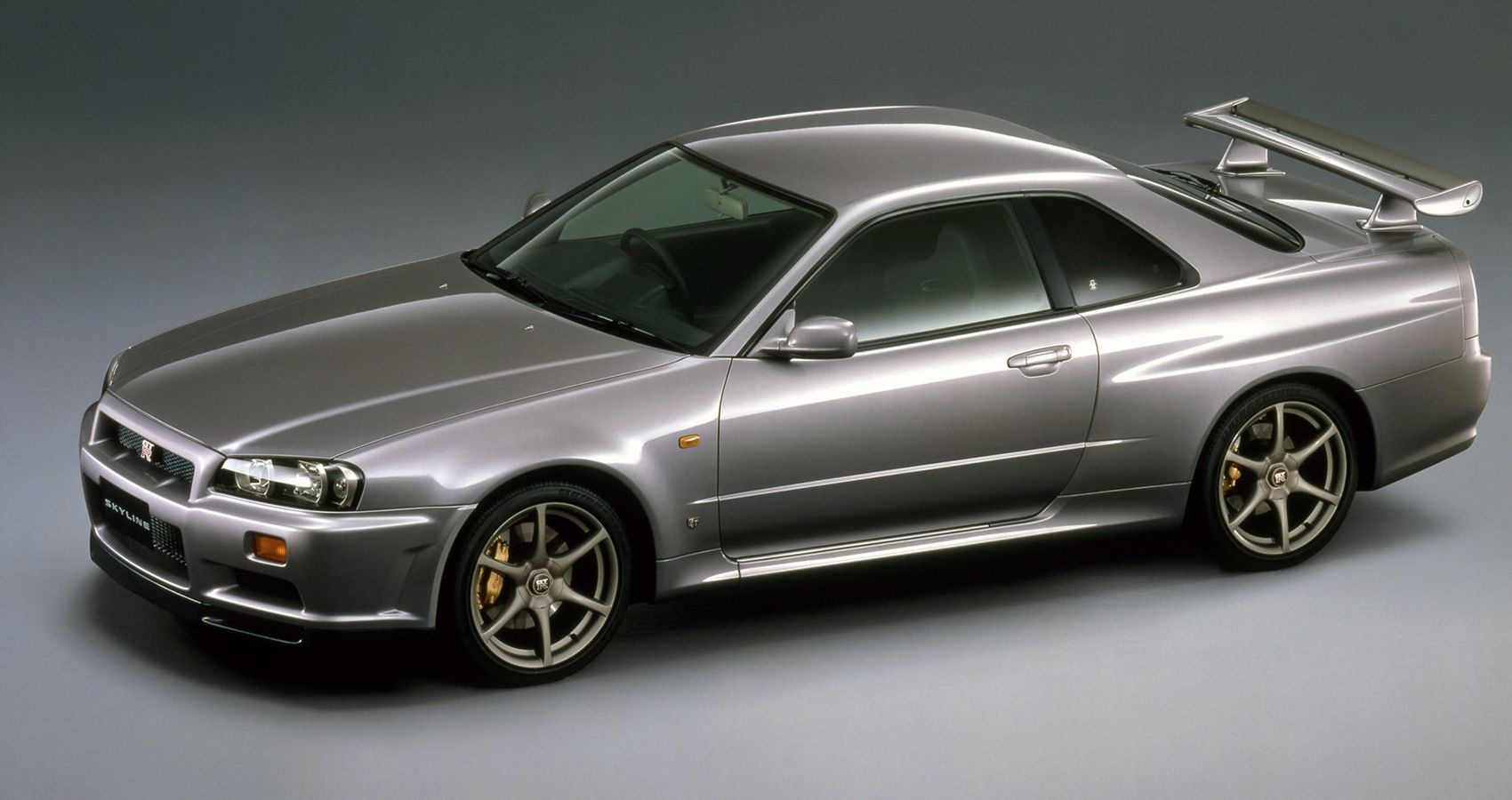 Front 3/4 view of a silver Skyline GTR R34, high angle