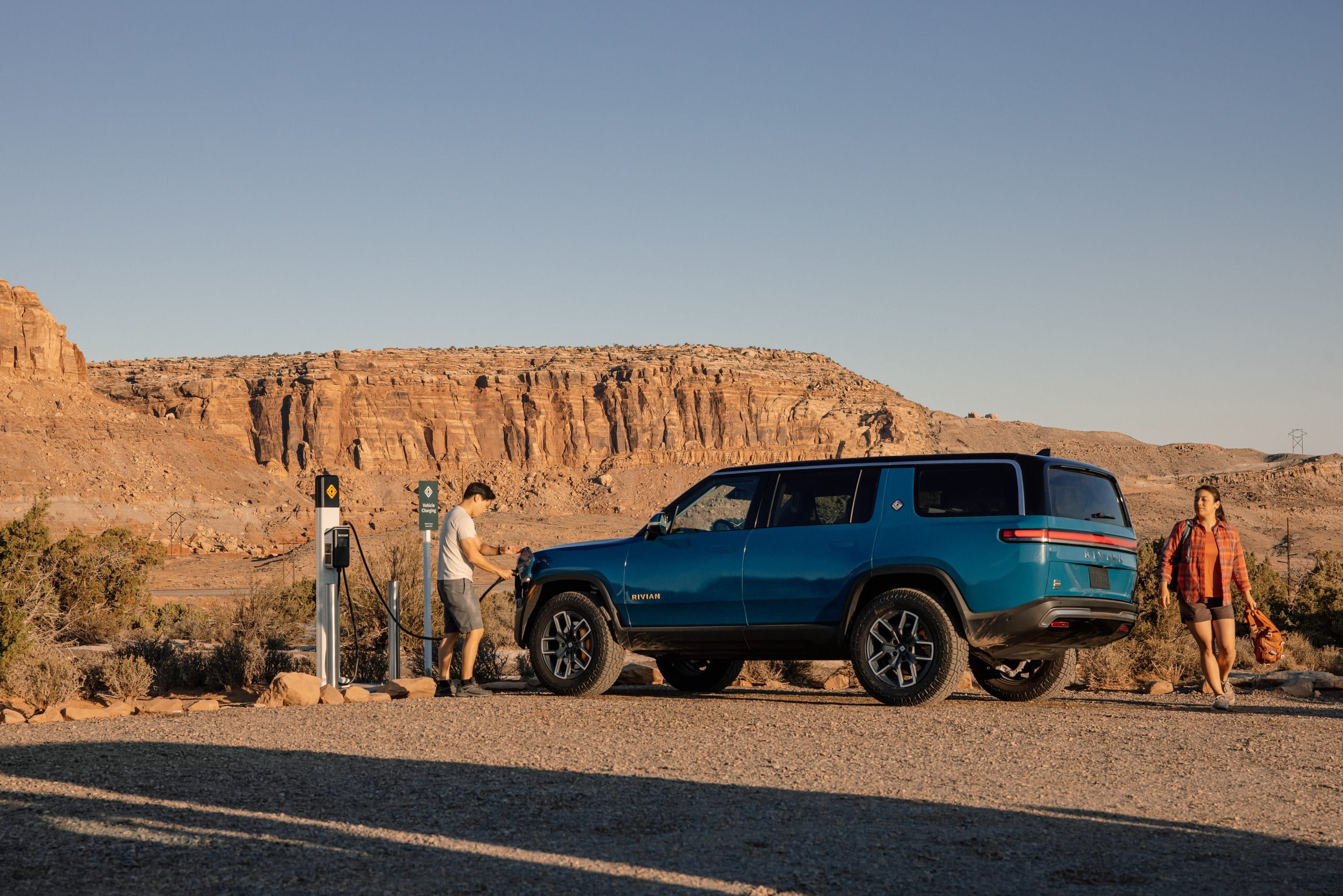Rivian R1S, blue, rear, desert with family