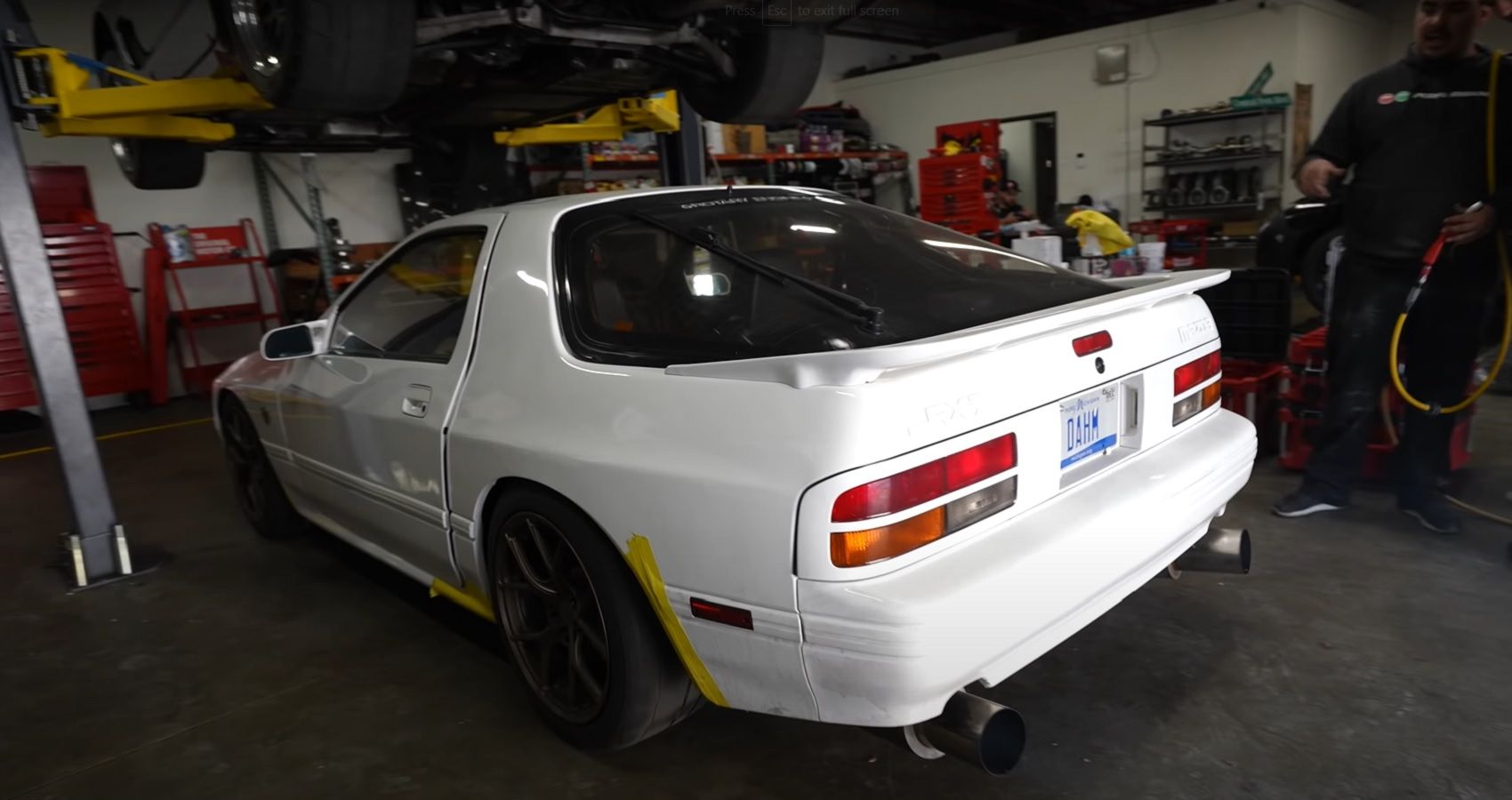 Rear quarter side of white Mazda RX-7 at the track