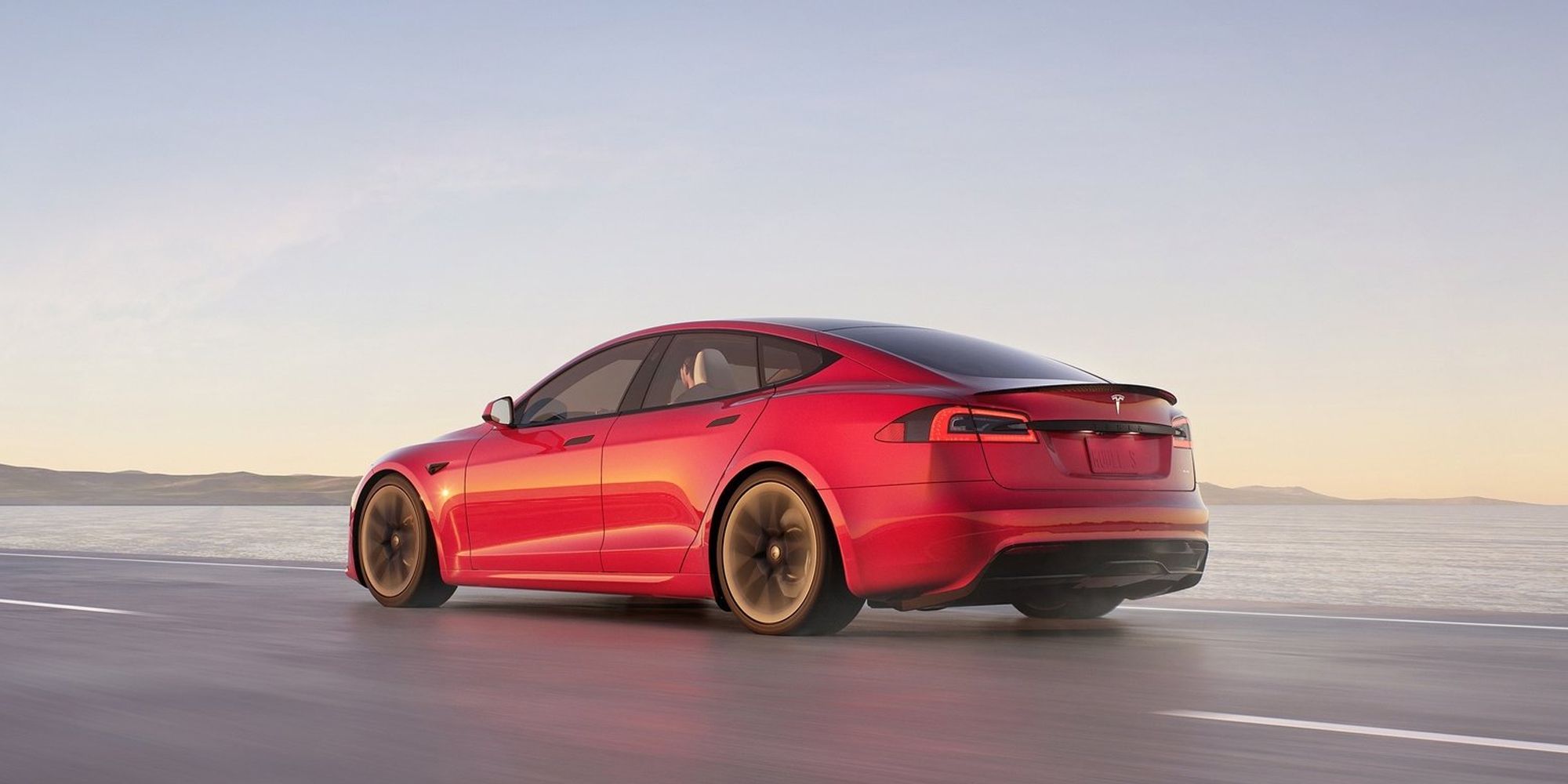 Rear 3/4 view of a red Model S Plaid in motion