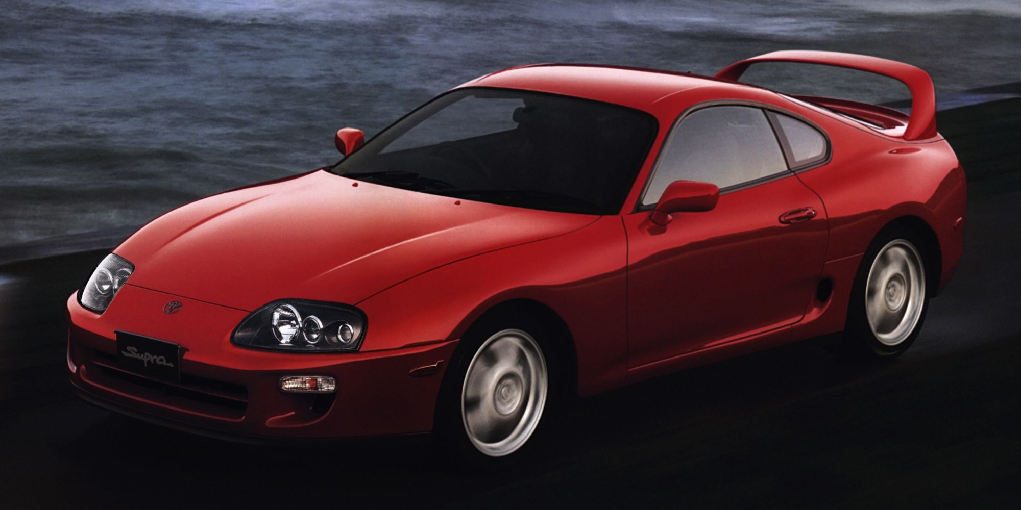 Front 3/4 view of a red Mk4 Supra on the move