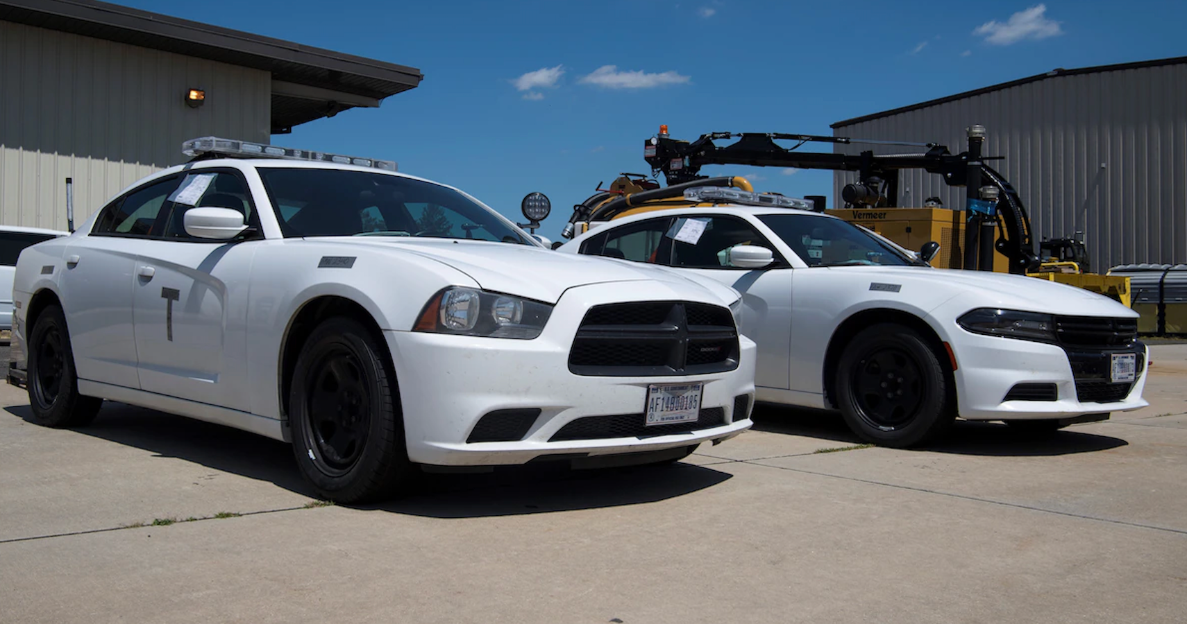 Two white Dodge Chargers parked side by side