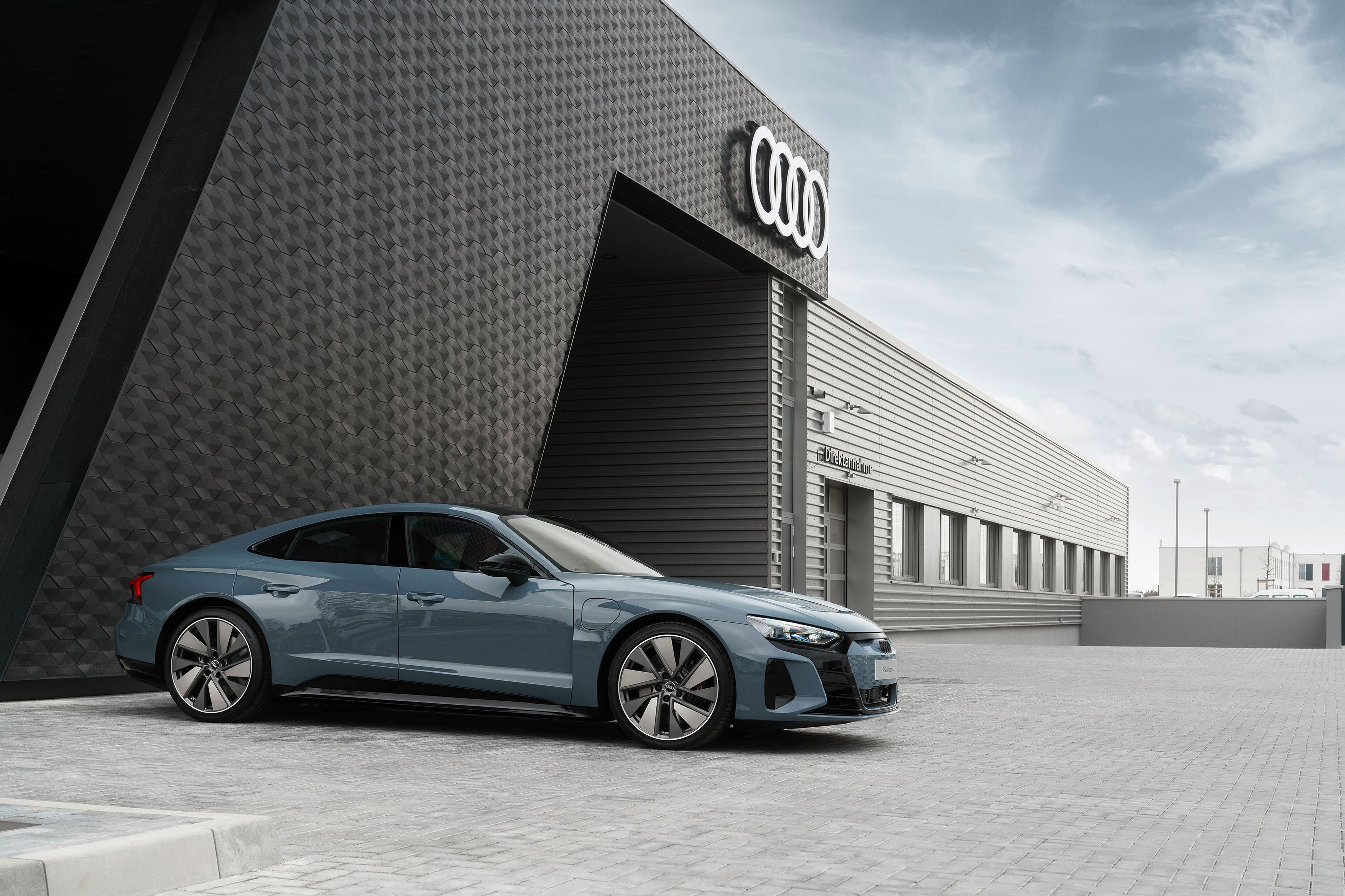 The Audi E-Tron GT parked in front of the Audi headquarters.