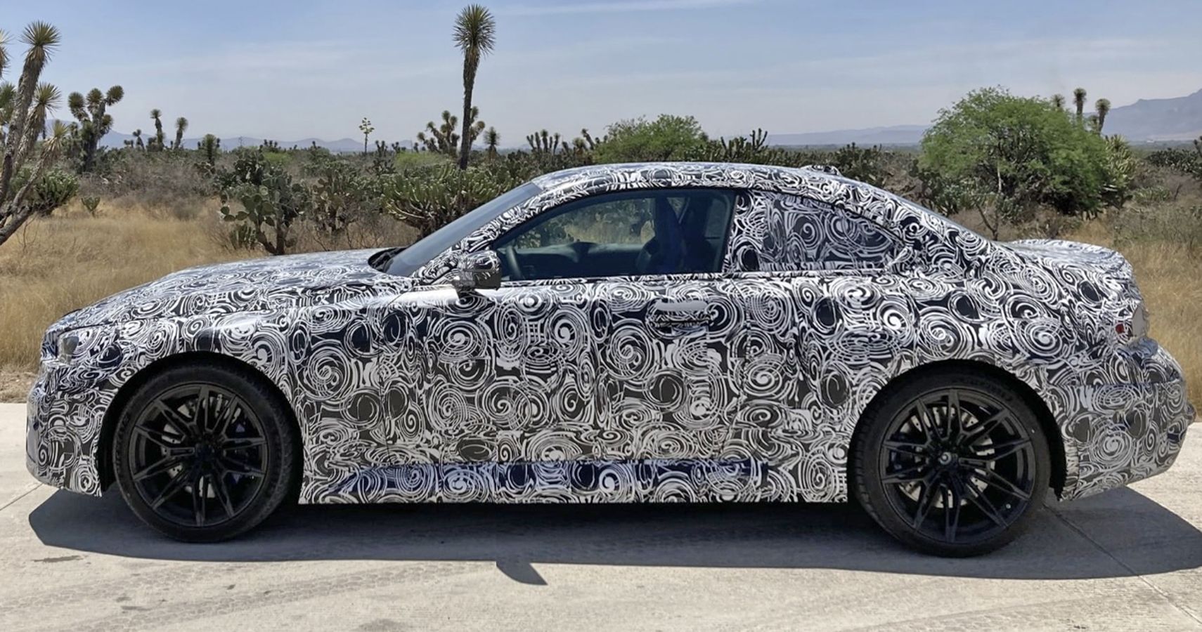 BMW M2 G87 prototype, side profile in Mexico, camouflaged exterior  