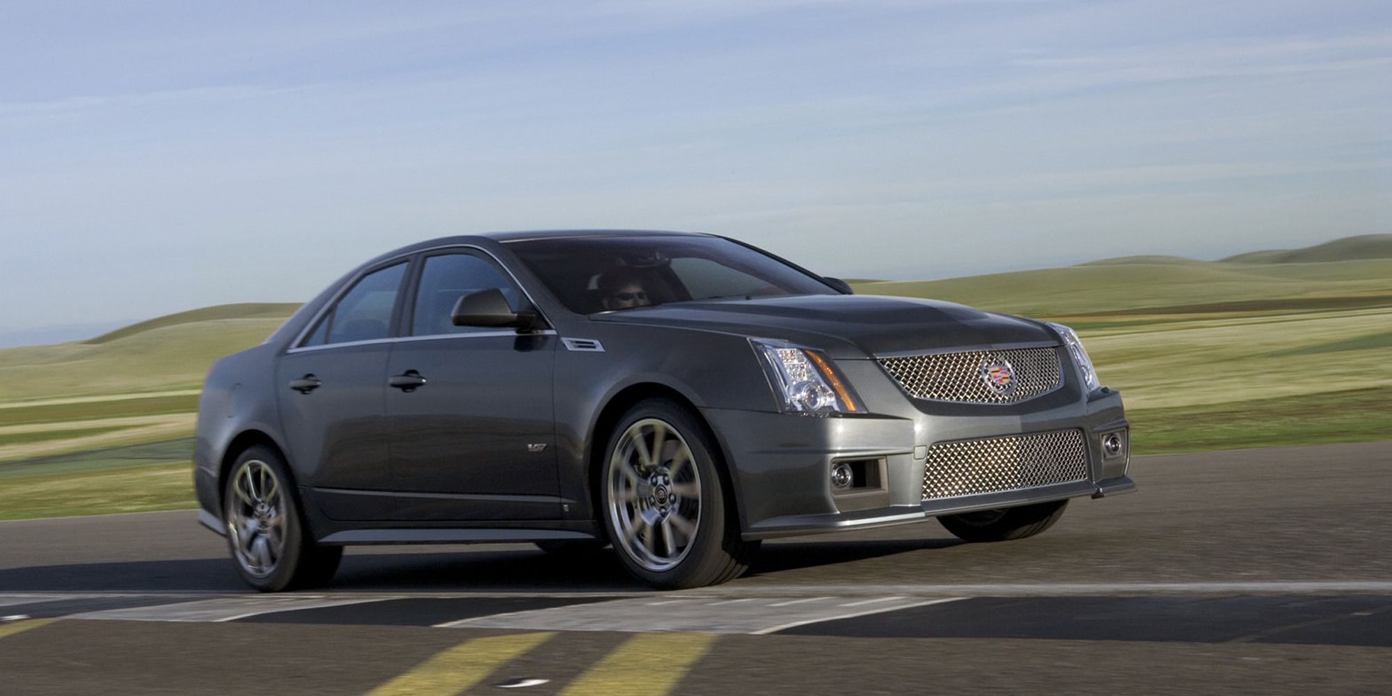 Front 3/4 view of a gray CTS-V sedan speeding on an airfield, right side