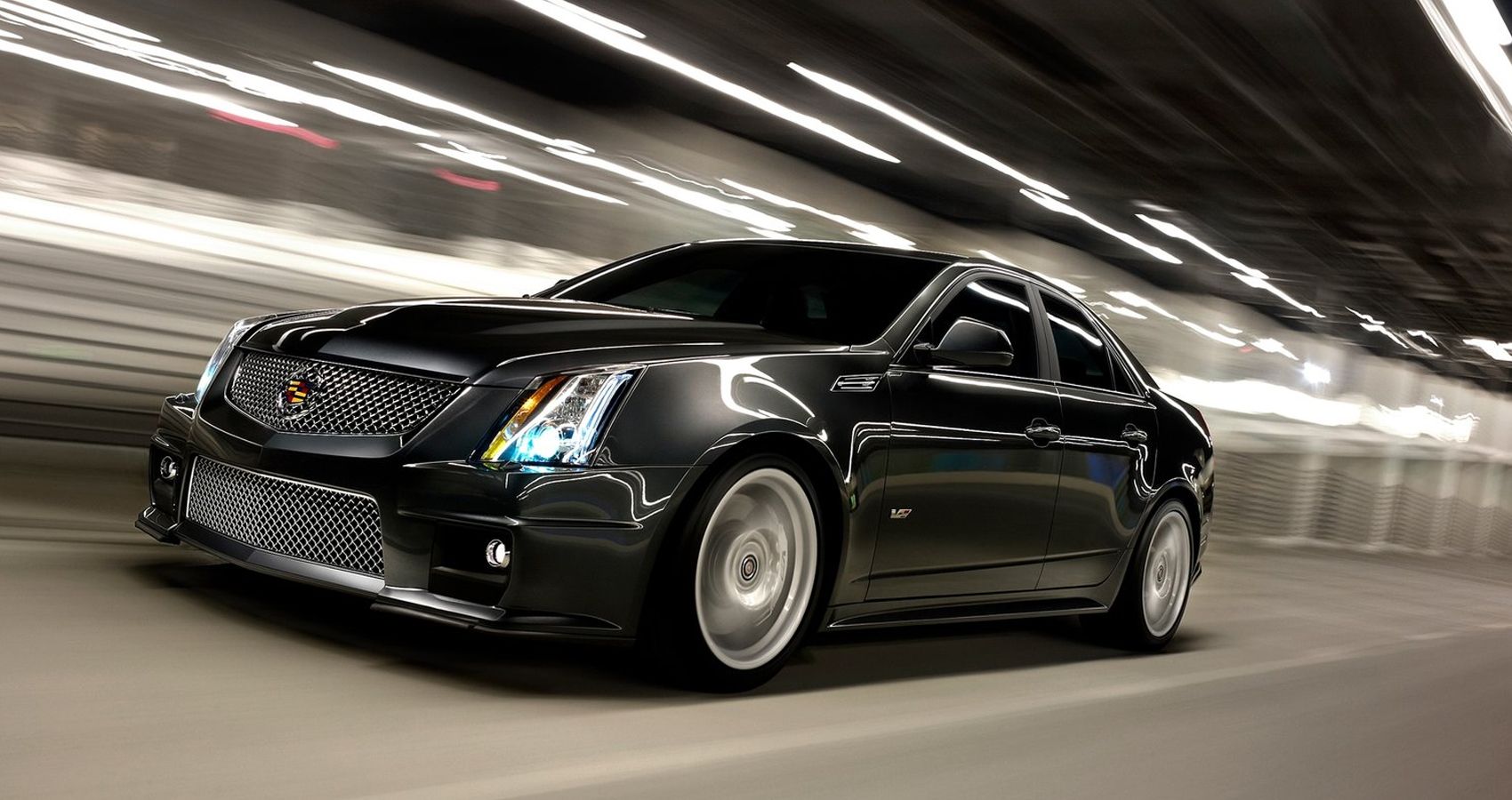 Front 3/4 view of a gray CTS-V speeding through a tunnel, long exposure shot