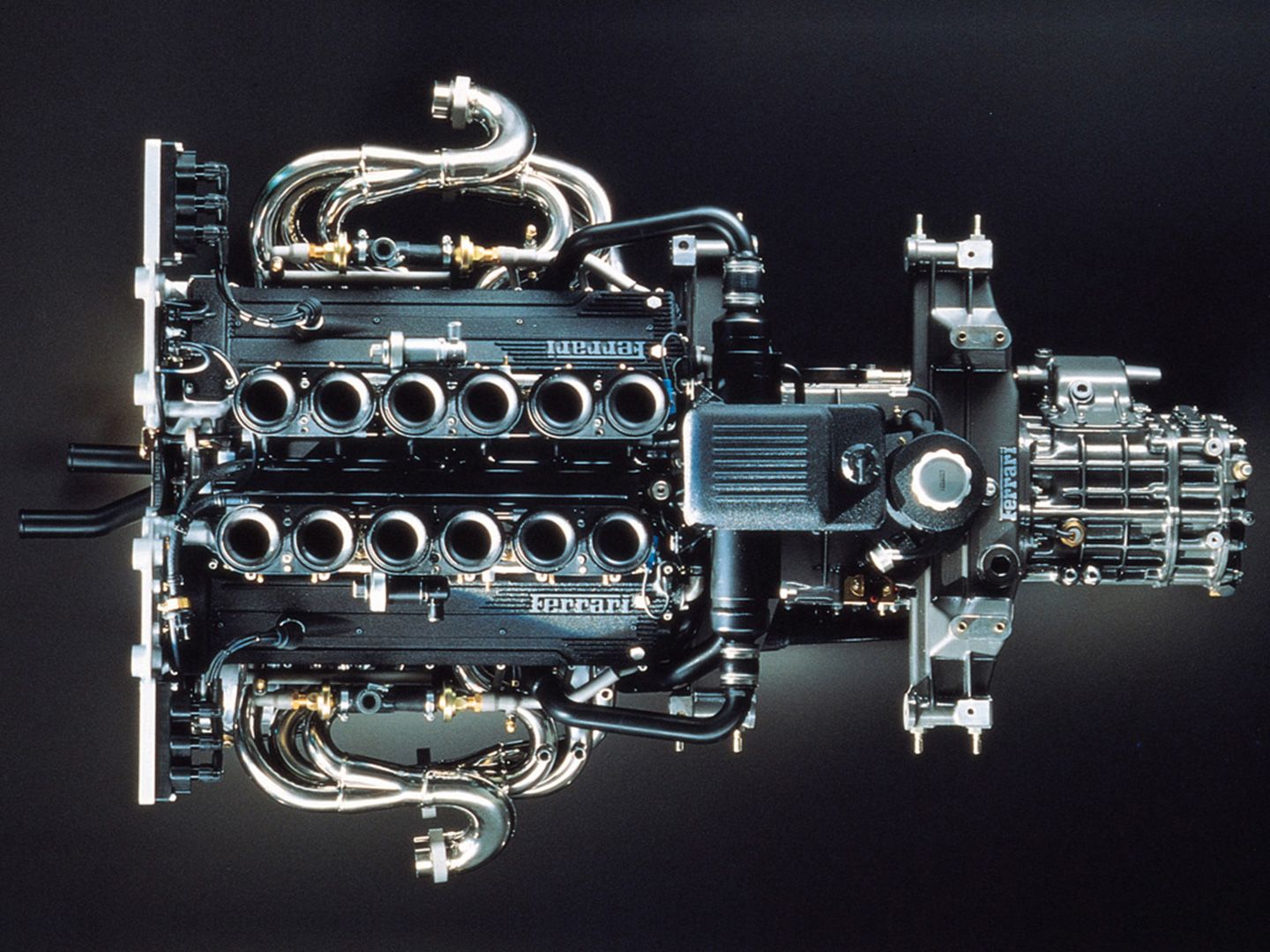 Ferrari F50 engine, dimly lit, plain background, from above