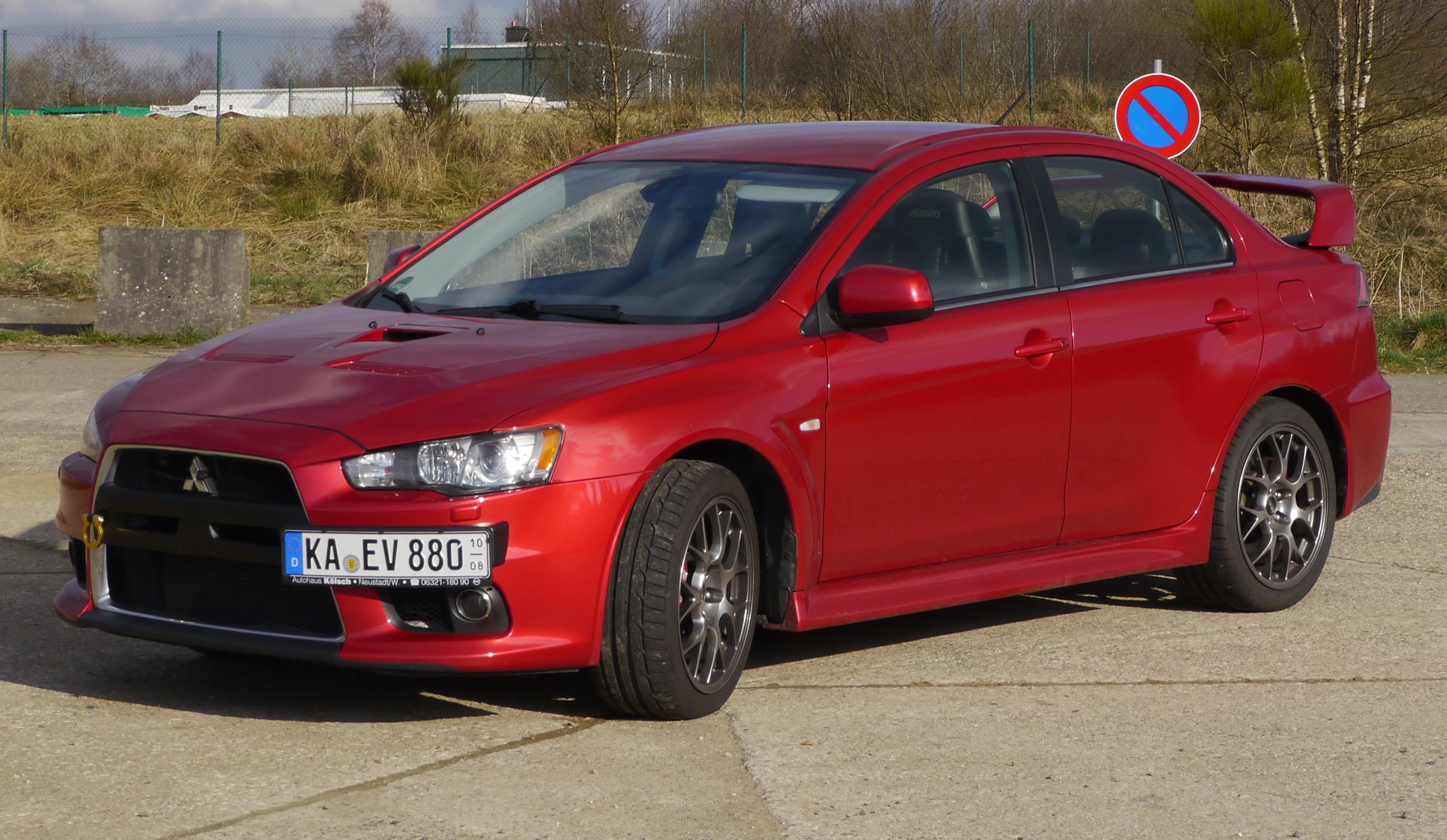 Red Mitsubishi Lancer Evolution, red, with rear spoiler, front quarter view