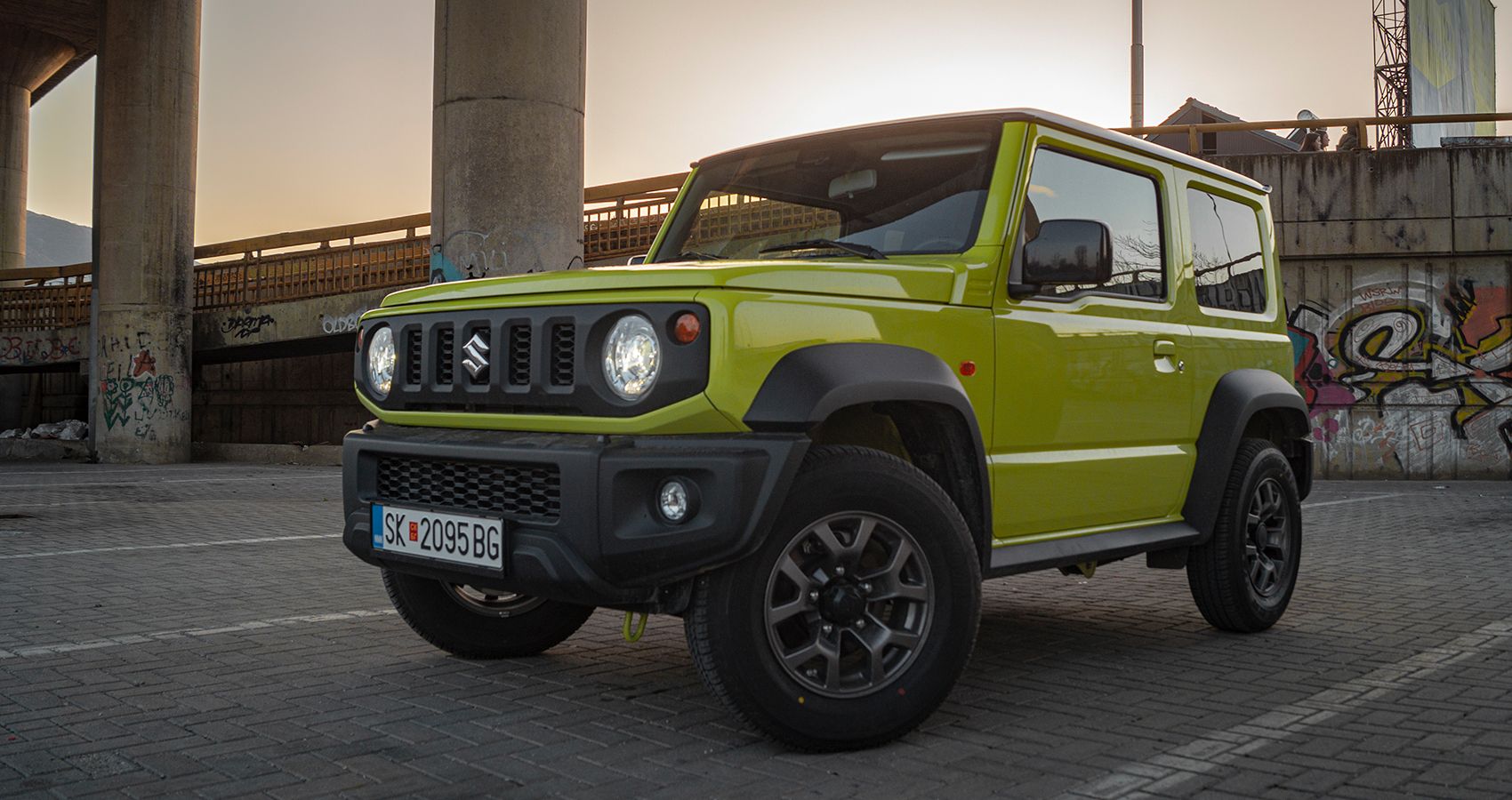 Front 3/4 view of a green Jimny in the sunset