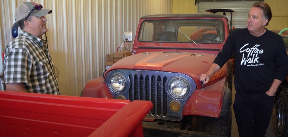 Red Jeeps inside garage, Dennis Collins and owner in foreground