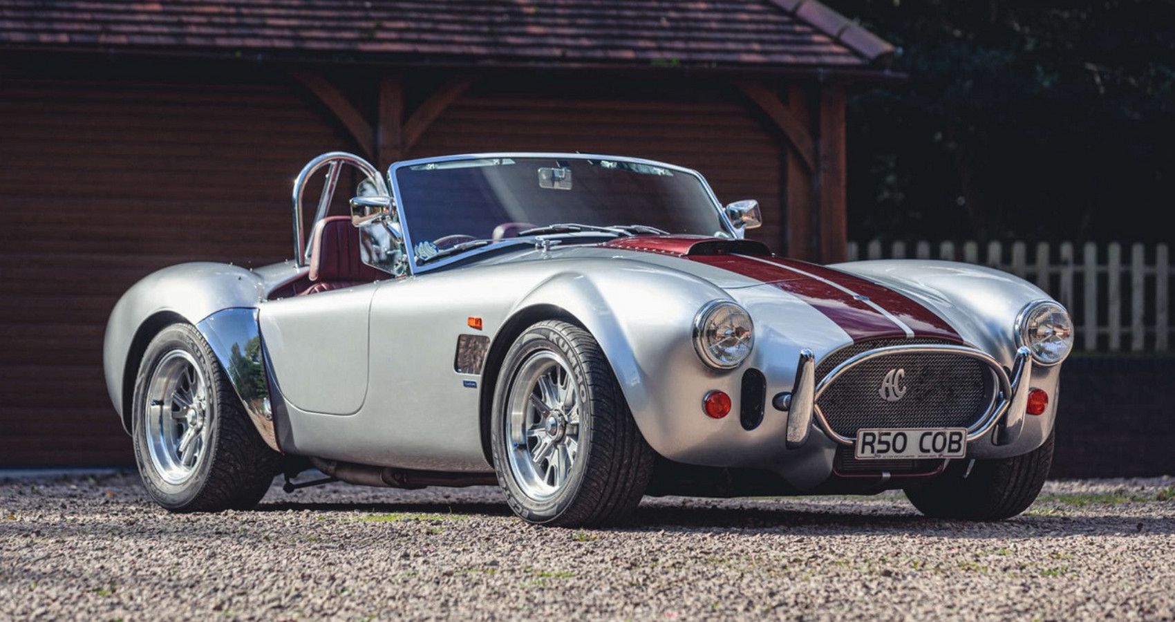 Silver and red AC Cobra sports car parked