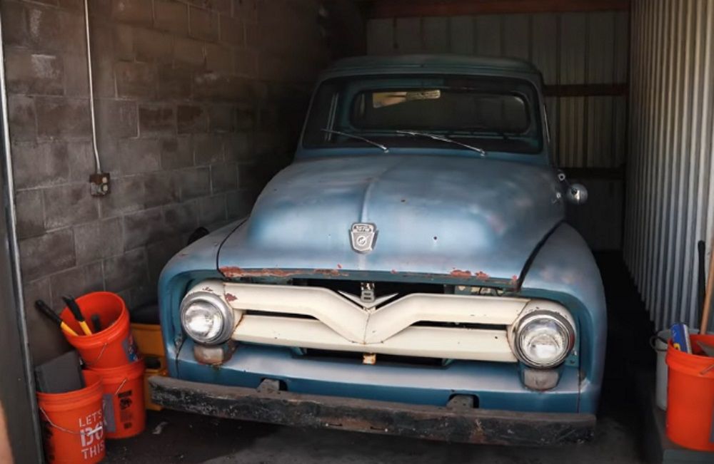 A blue 1955 Ford F-100, front view from outside garage