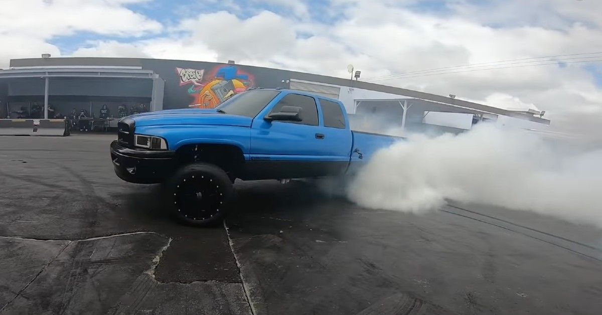 Blue 1998 Dodge Ram smoking tires
